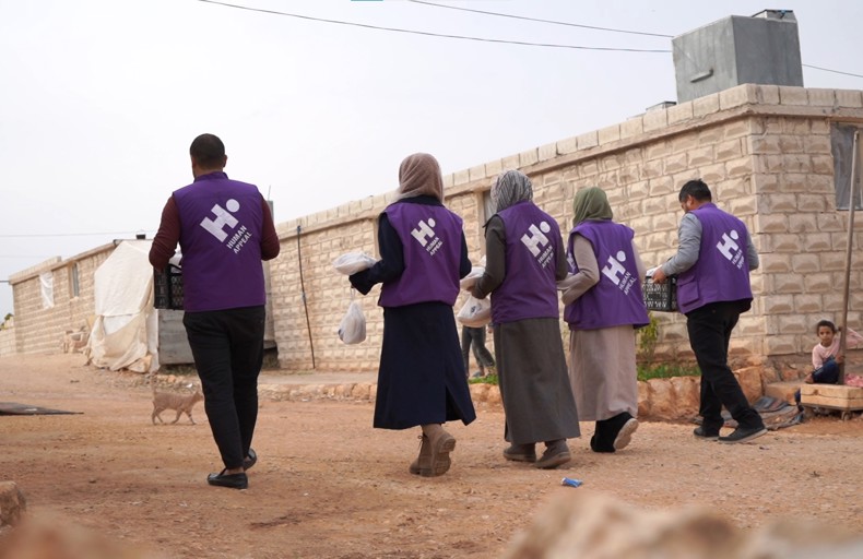 Human Appeal staff carrying hot meals to distribute in Syria